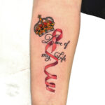 Tatouage de couronne et de ruban sur l'avant-bras