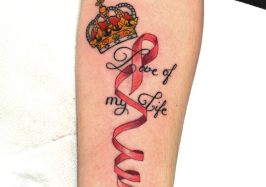 Tatouage de couronne et de ruban sur l'avant-bras