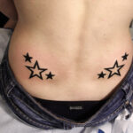 Petit tatouage d'étoiles dans le bas du dos