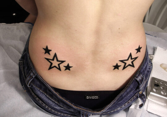 Petit tatouage d'étoiles dans le bas du dos
