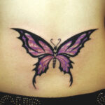 Tatouage de papillon violet sur le bas du dos