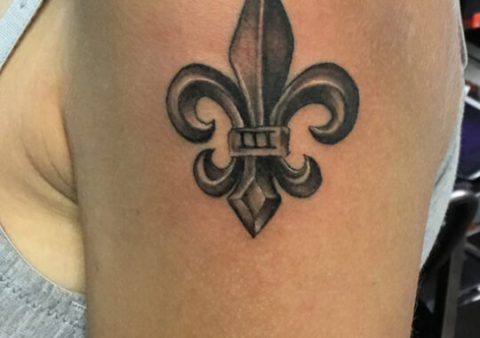 Petit tatouage fleur de lys réaliste réalisé à Aix-en-Provence