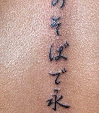Tatouage lettrage alphabet asiatique dans le dos