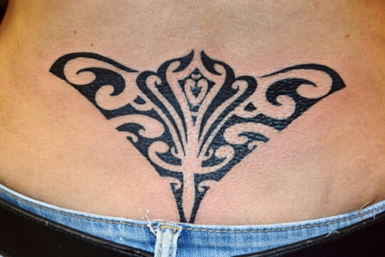 Tatouage maori de raie manta dans le bas du dos réalisé à Aix-en-Provence